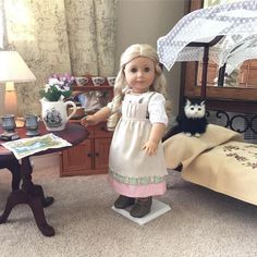 a doll standing next to a bed with an owl on it