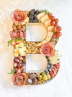 the letter b is made up of fruits, cheeses and meats with flowers