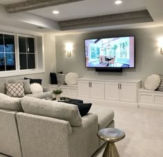 a living room filled with furniture and a flat screen tv mounted to the side of a wall