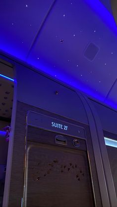 the interior of an airplane with blue lights and stars on the ceiling above it is a suite 47 door