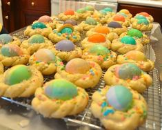 there are many colorful cookies on the cooling rack