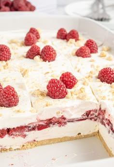 a cake with raspberries and cream on top