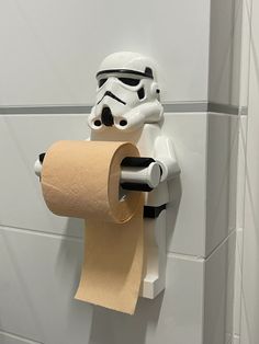 a storm trooper toilet paper holder with a roll of toilet paper hanging from it's side