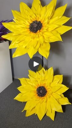 two large yellow flowers sitting on top of a table