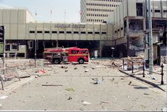 a red fire truck parked in front of a large building with lots of debris on the ground