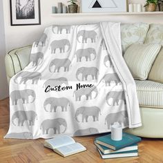 an elephant blanket with the name custom home on it next to books and a cup