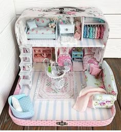 a doll house with furniture and accessories in the middle of it on a wooden floor