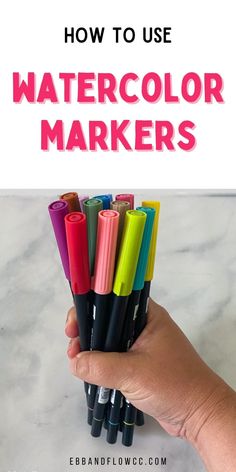 a hand holding a bunch of markers with the words how to use watercolor markers