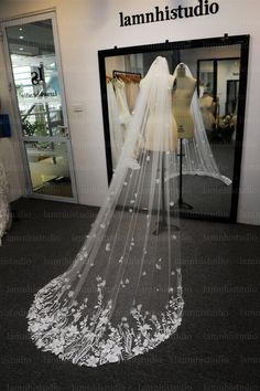 a wedding veil is on display in front of a mannequin