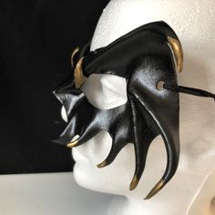 DESCRIPTIONMystify the mortals at the Halloween masquerade with a gold-tipped, black leather vampire mask! Perfect for masquerade parties or theatre productions. Get this gold-tipped mask for Halloween or Vampire Masquerade. A sexy costume accessory for your vampire costume, and a fantastic festival mask! Add to a RenFaire costume. Any color. Waterproofed leather, glossy or matte finish, & several choices to affix the mask (cord, elastic, ribbon, waterproof cord, stick, or no holes for adhesive) Black Gothic Masks For Fantasy Events, Gothic Masks And Prosthetics For Mardi Gras Cosplay, Steampunk Halloween Party Masks, Halloween Theater Mask, Black Steampunk Masks For Masquerade, Steampunk Black Masquerade Masks And Prosthetics, Phantom Masquerade Mask For Halloween, Gothic Masquerade Mask For Halloween Theater, Steampunk Black Masquerade Mask