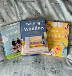 three children's books sitting on top of a bed next to eachother