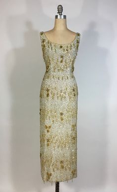 "It is an honor and a pleasure to be listing this breath-taking, fabulous, rare, Samuel Winston by Roxane gown! This late 1950's gown (so, slightly post-Charles James designs for the company) is truly a spectacular, museum-quality gem. The ivory colored crepe silk base of this dress is layered over in a silk chiffon that's heavily hand-beaded, with glass bugle beads, in squiggling bands of alternating silver and gold. These gold bands feature gold seed beads fringe loop droplets, seed bead leaves, flower buds with aurora borealis bead centers and oblong metallic gold bead petals. The overall beading on this dress was excellent when found. I have replaced two small areas of missing beading and secured any loose spots. Back of dress has low-cut scoop and metal zipper closure at center back, Vintage Gold Evening Dress For Gala, Vintage Floor-length Gown For Gala, Vintage Floor-length Gala Gown, Vintage Floor-length Evening Dress For Vintage Events, Vintage Gala Gown With Fitted Bodice, Vintage Gold Evening Dress For Wedding, Vintage Gown With Fitted Bodice For Gala, Embellished Floor-length Vintage Evening Dress, Vintage Floor-length Evening Gown