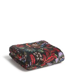 a black and red floral print blanket sitting on top of a white surface