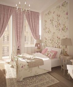 a bedroom decorated in pink and white with floral wallpaper, chandelier and bed