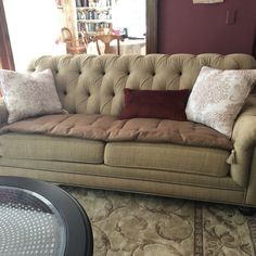 a living room couch with many pillows on it