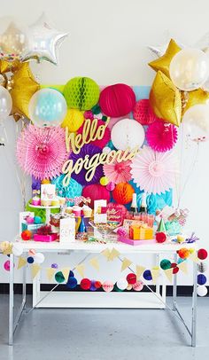 a table topped with lots of balloons and decorations