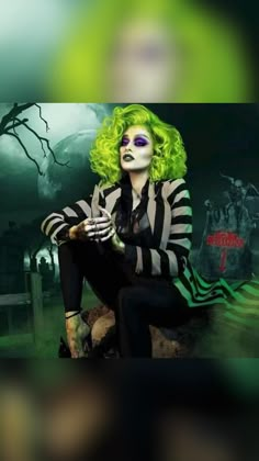 a woman with green hair and makeup sitting on a rock