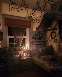 a bedroom with a bed, window and plants hanging from it's ceiling in the dark