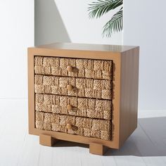 a wicker drawer with three drawers and two knobs on the front is shown against a white wall