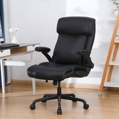 a black office chair sitting in front of a computer desk