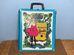 a blue suitcase with an advertisement for barbie on it