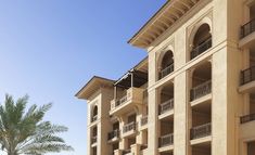 an apartment building with balconies and palm trees