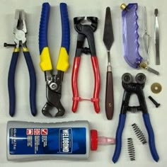 various tools are laid out on a white surface, including pliers and other items