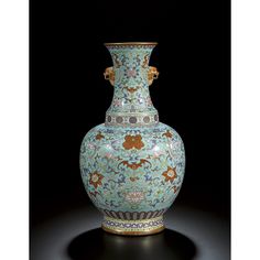 an ornate vase is sitting on a black surface