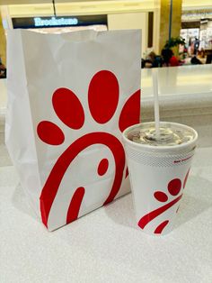 a paper bag with a drink in it sitting on a counter next to a cup