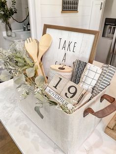 a basket filled with kitchen utensils sitting on top of a counter next to a sign