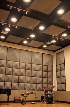 an empty room with some lights on the ceiling and musical instruments in front of it