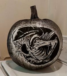 a black and white painted pumpkin sitting on top of a dryer door sill