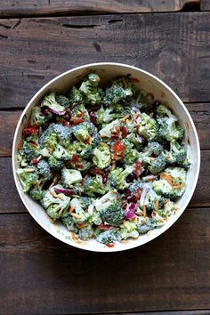 a bowl filled with broccoli on top of a wooden table