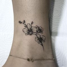 a black and white flower tattoo on the ankle