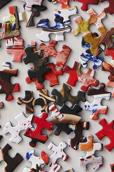 many different colored pieces of puzzle laying on top of each other