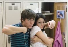 a young man and woman hugging in front of lockers with their arms around each other