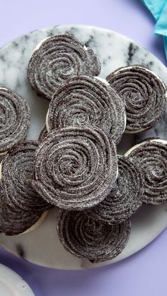 several rolled up cookies on a plate next to some napkins and a blue cloth