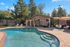 a backyard with a swimming pool and patio furniture