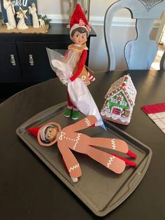 an elf is sitting on top of a tray with scissors and other crafting supplies