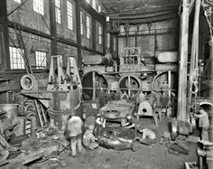 an old black and white photo of men working in a factory