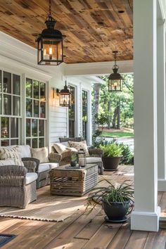 the porch is covered with wicker furniture and potted plants