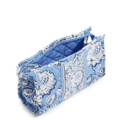 a blue and white bag with flowers on the inside is sitting in front of a white background