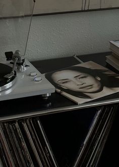 a record player sitting on top of a table next to a stack of vinyl records