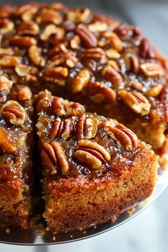 a cake with pecans on top sitting on a plate