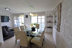 a dining room table with chairs and a television on the wall in front of it