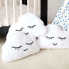 two pillows with eyes drawn on them next to a crib