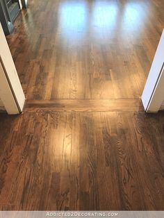 an empty room with hard wood floors and white trim