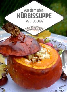 a close up of a pumpkin on a plate with spoons and leaves around it