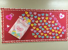 a valentine's day bulletin board with hearts and a candy bar on the front