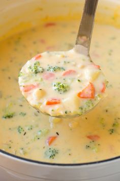 a ladle full of soup with broccoli and carrots